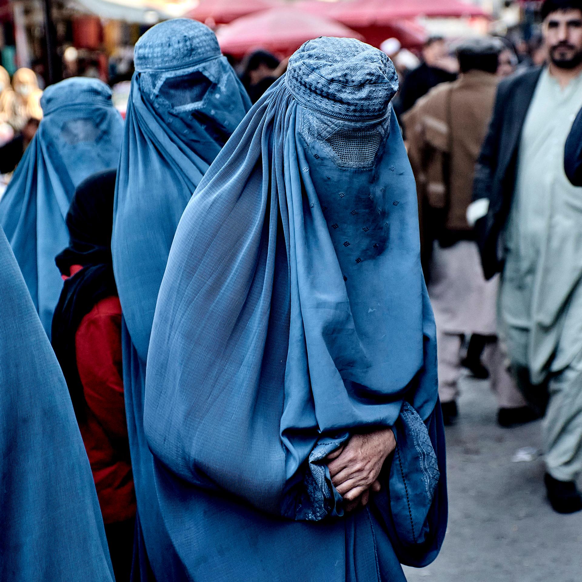 Frauen auf einem Markt im Land Afghanistan. Sie müssen Körper und Gesicht mit Stoff verhüllen. 