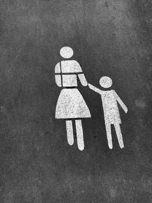 Darstellung von Mutter mit Kind an der Hand als Markierung auf dem Straßenpflaster