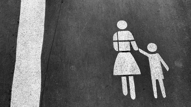 Darstellung von Mutter mit Kind an der Hand als Markierung auf dem Straßenpflaster