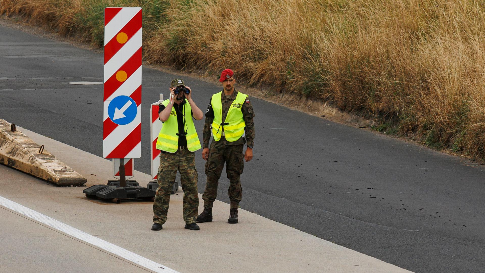 Polnische Grenzpolizisten kontrollieren Fahrzeuge an einem Kontrollpunkt in Jedrzychowice-Ludwigsdorf an der Grenze zu Deutschland. Polnische Grenzpolizisten kontrollieren Fahrzeuge an einem Kontrollpunkt in Jedrzychowice-Ludwigsdorf an der Grenze zu Deutschland.