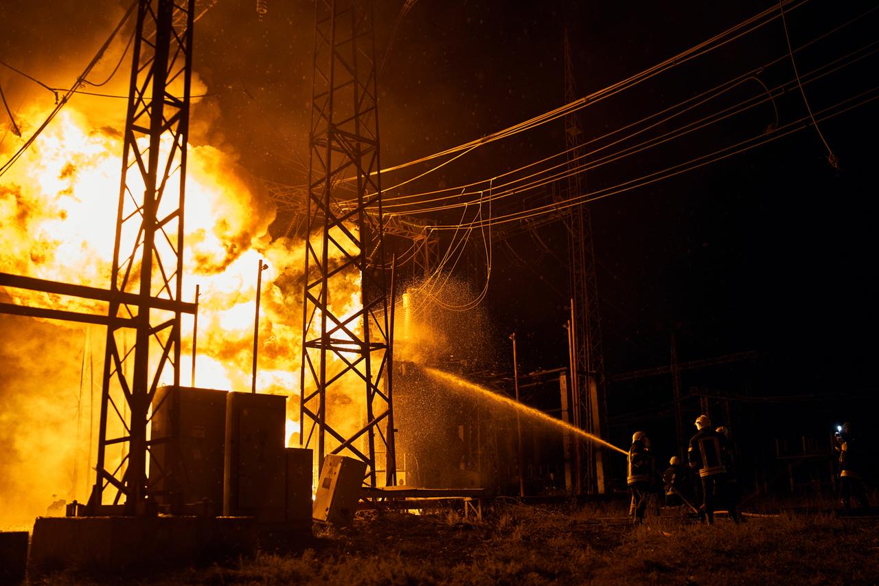 Ein E-Werk brennt. Ukrainische Feuerwehrleute versuchen nachts, die Flammen zu löschen.