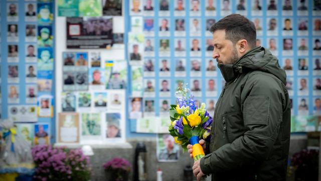 Wolodymyr Selenskyj im Profil, er hält einen Blumen-Strauß in den Farben der Ukraine in Händen.