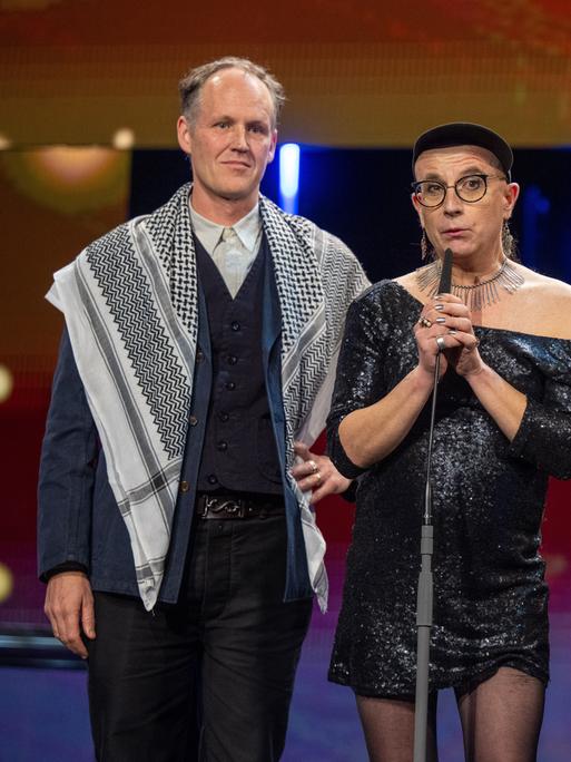 Vier Künstler stehen auf einer Bühne bei der Preisgala der Berlinale. Zwei Künstler tragen ein sogenanntes  Palästinensertücher.