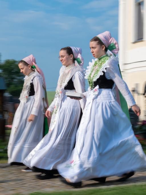 Sorbischen Mädchen in Tracht kommen zum Fronleichnamsgottesdienst