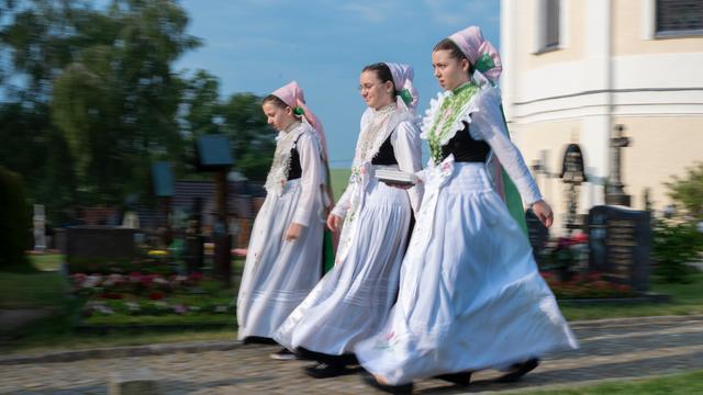 Sorbischen Mädchen in der Tracht einer Druschka kommen zum Fronleichnamsgottesdienst. Das "Hochfest des allerheiligsten Leibes und Blutes Christi" ist in der sorbischen Lausitz ein Feiertag und wird mit Gottesdiensten und Prozessionen gefeiert.