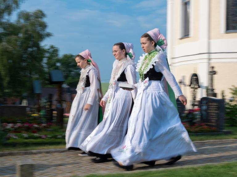 Sorbischen Mädchen in Tracht kommen zum Fronleichnamsgottesdienst
