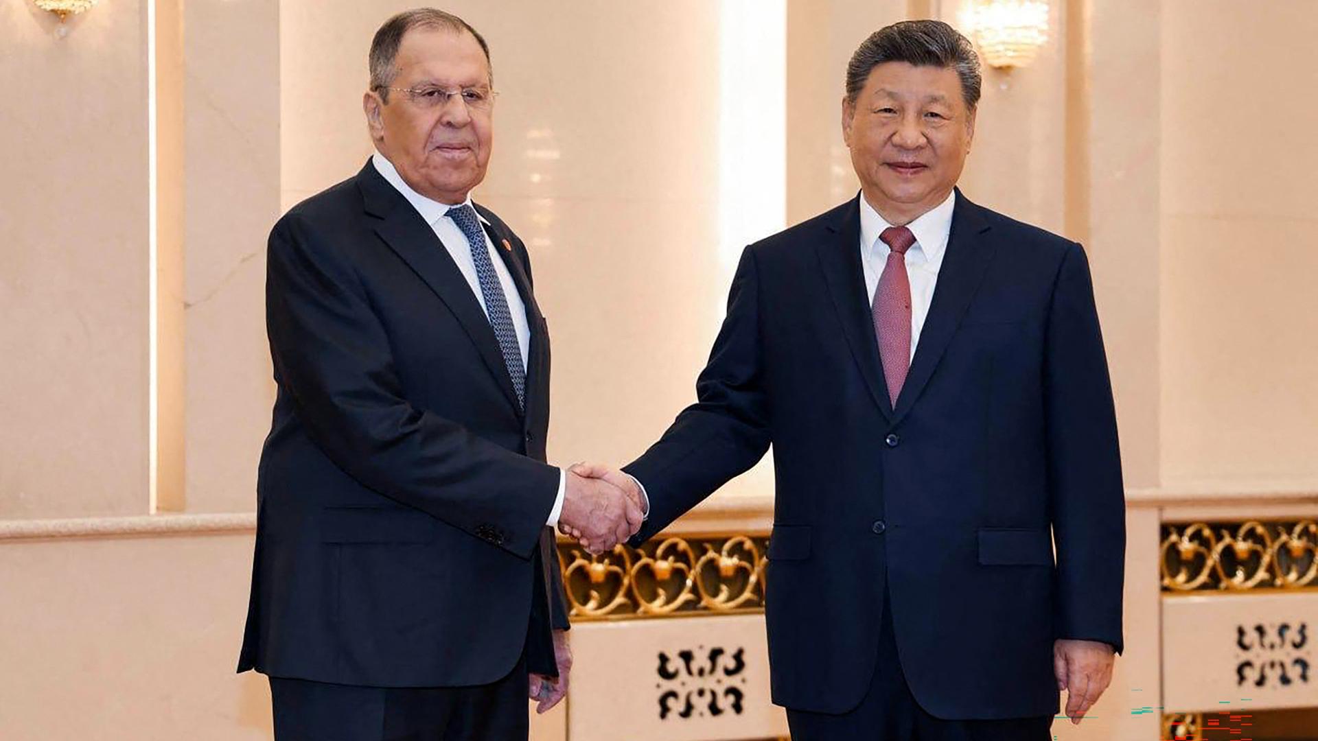 Der russische Außenminister Lawrow (l.) und der chinesische Staatschef Xi geben sich die Hand. Der russische Außenminister Lawrow (l.) und der chinesische Staatschef Xi geben sich die Hand.