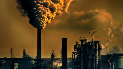 Ein Industrischornstein blässt Abgase in dei Atmosphäre.