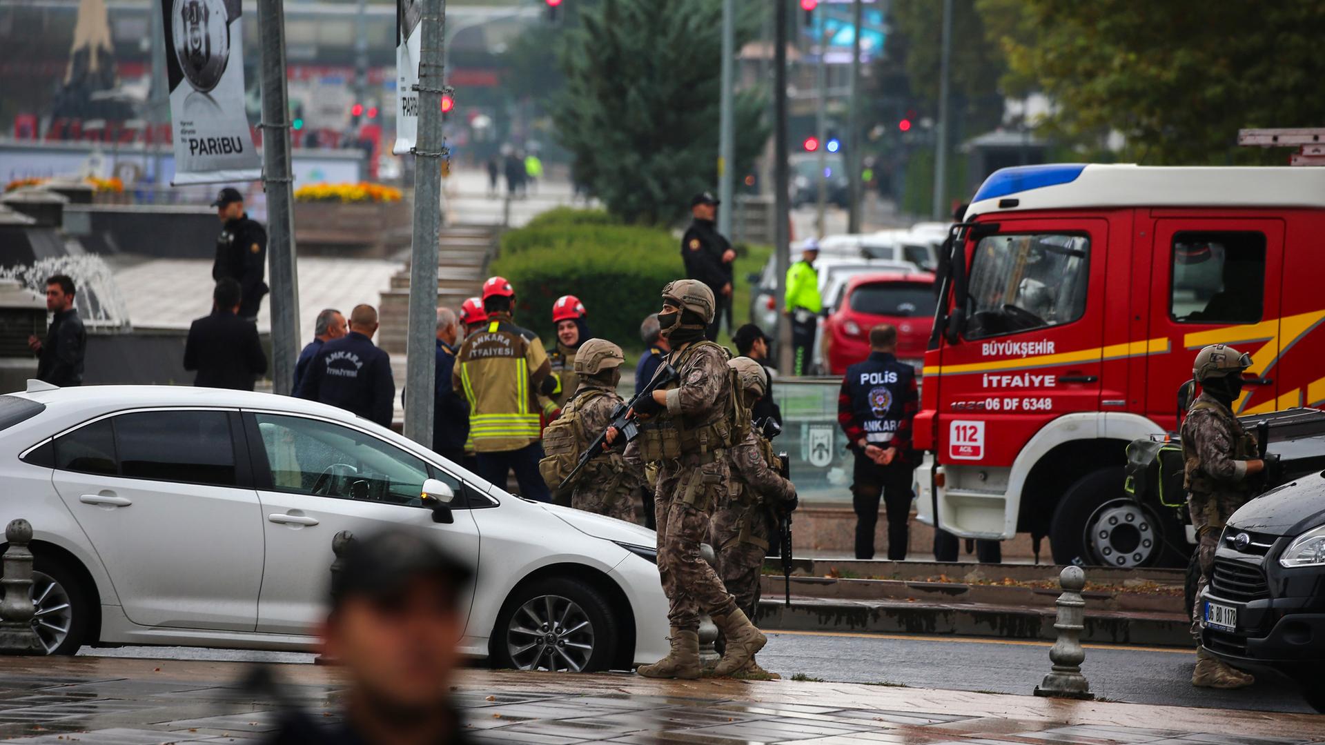 Rettungskräfte und schwer bewaffnete Polizisten stehen auf einer Straße in der Nähe des türkischen Parlaments in Ankara.
