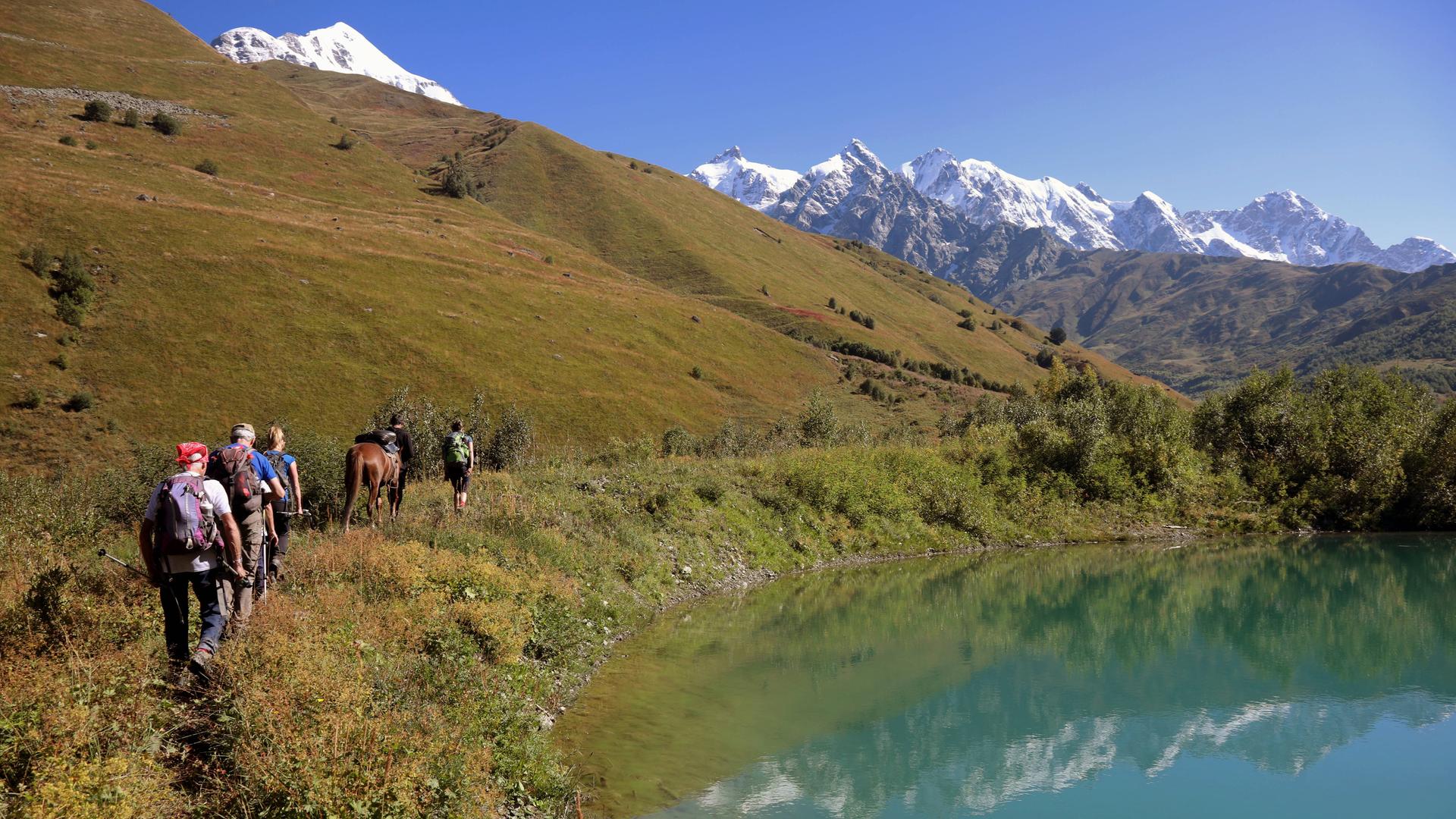 Menschen bei einer Wanderung im Tal an einem See im Kaukasus in Georgien. Menschen bei einer Wanderung im Tal an einem See im Kaukasus in Georgien.