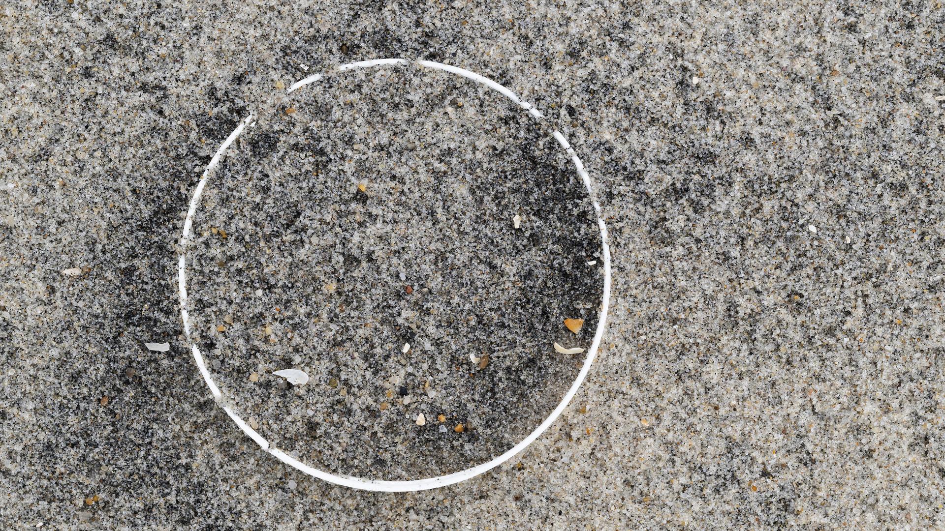 Überreste einer Plastikflasche im Sand am Strand Überreste einer Plastikflasche im Sand am Strand