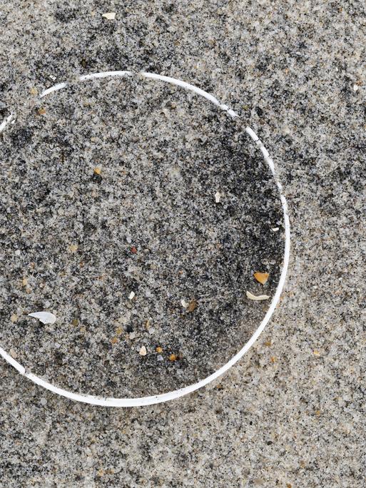 Überreste einer Plastikflasche im Sand am Strand 