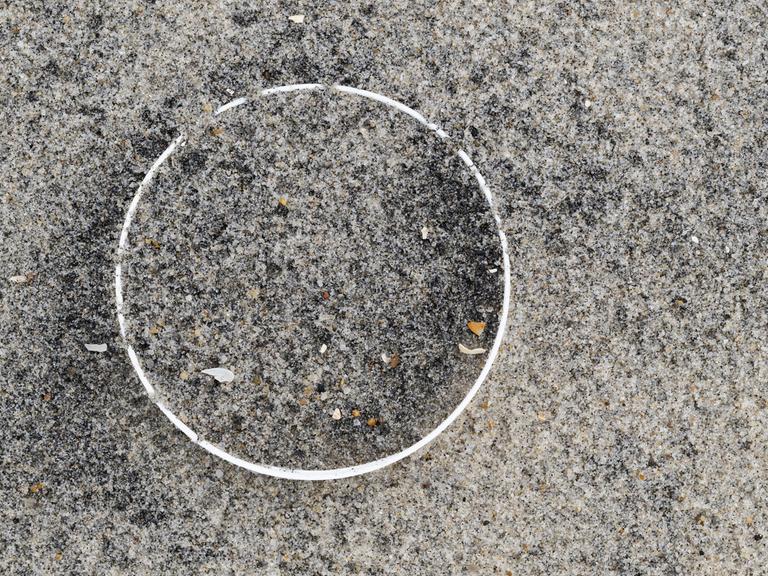 Überreste einer Plastikflasche im Sand am Strand 