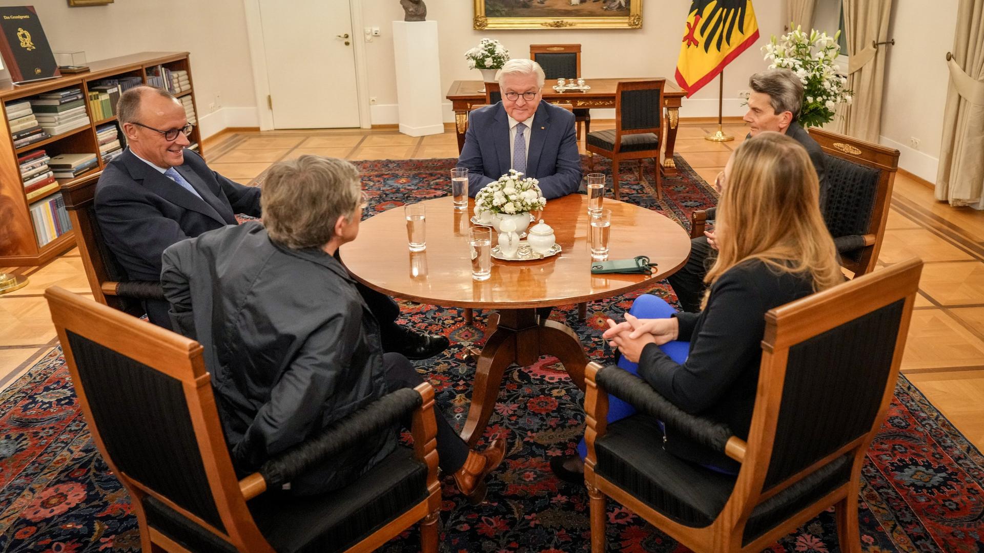 Friedrich Merz, Britta Haßelmann, Katharina Dröge und Rolf Mützenich sitzen mit Bundespräsident Frank-Walter Steinmeier im Schloss Bellevue zusammen.