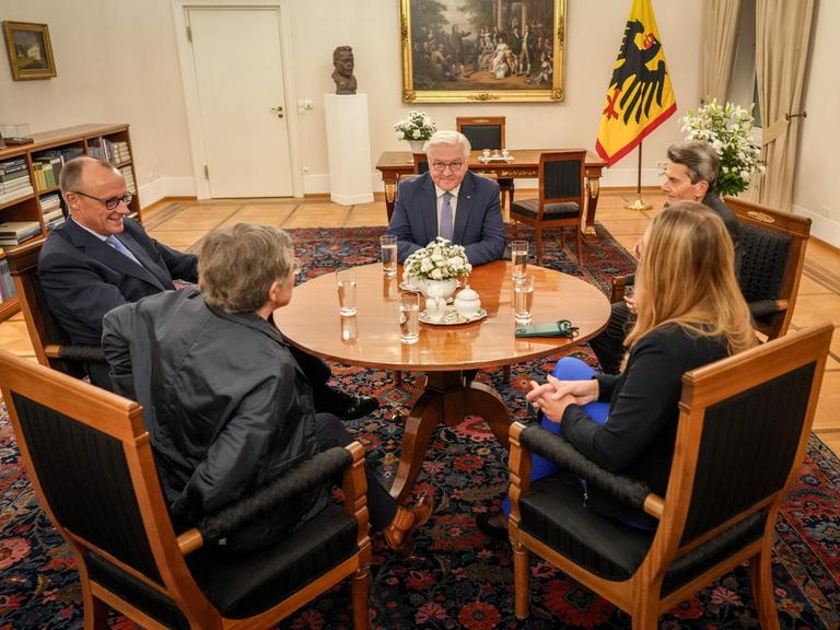 Friedrich Merz, Britta Haßelmann, Katharina Dröge und Rolf Mützenich sitzen mit Bundespräsident Frank-Walter Steinmeier im Schloss Bellevue zusammen.