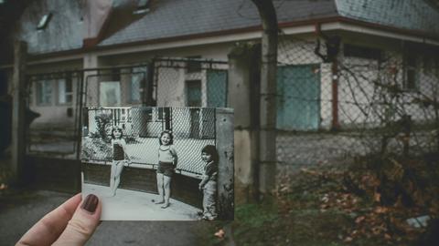 Ein Abgleich mit der Vergangenheit: Eine Frau hält an einem einsamen Schauplatz ein Schwarz-Weiß-Foto mit drei Kindern hoch - aufgenommen exakt an diesem Ort.