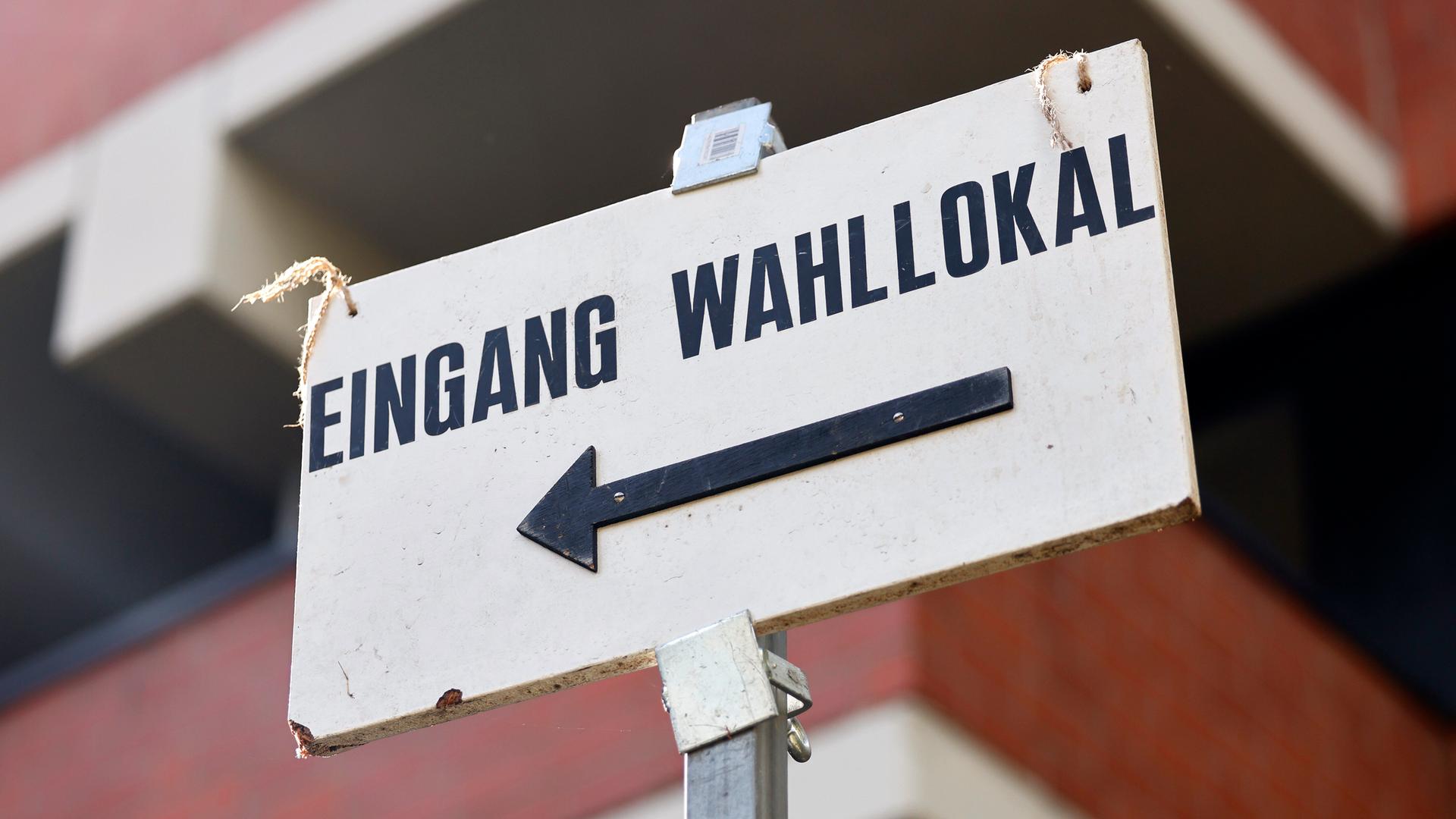 Ein Schild weist den Weg zu einem Wahllokal.