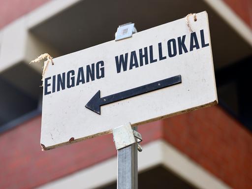 Ein Schild weist den Weg zu einem Wahllokal.