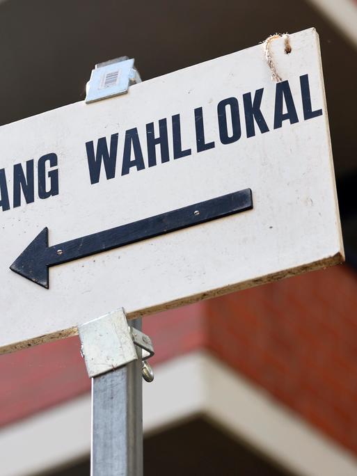 Ein Schild weist den Weg zu einem Wahllokal.