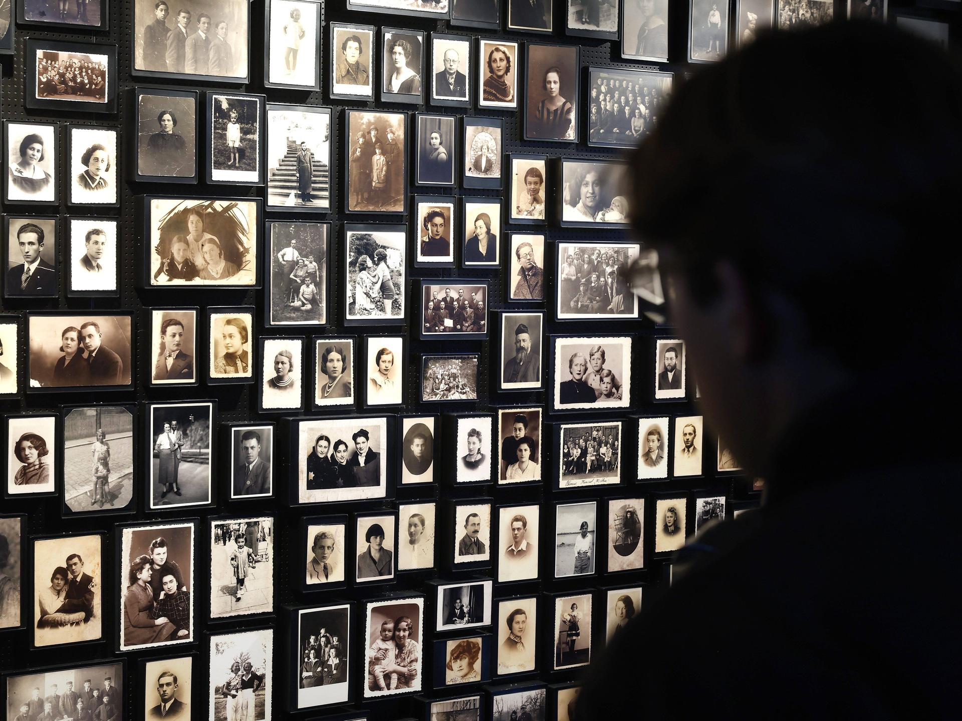 Bilder von Opfern des Holocaust hängen an einer Wand des Konzentrationslagers Auschwitz Birkenau