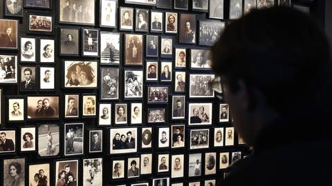 Bilder von Opfern des Holocaust hängen an einer Wand des Konzentrationslagers Auschwitz Birkenau.