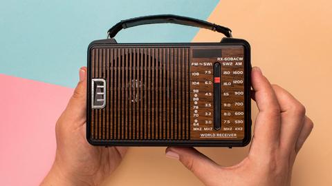 Ein kleines Retro-Radio in der Hand einer Person