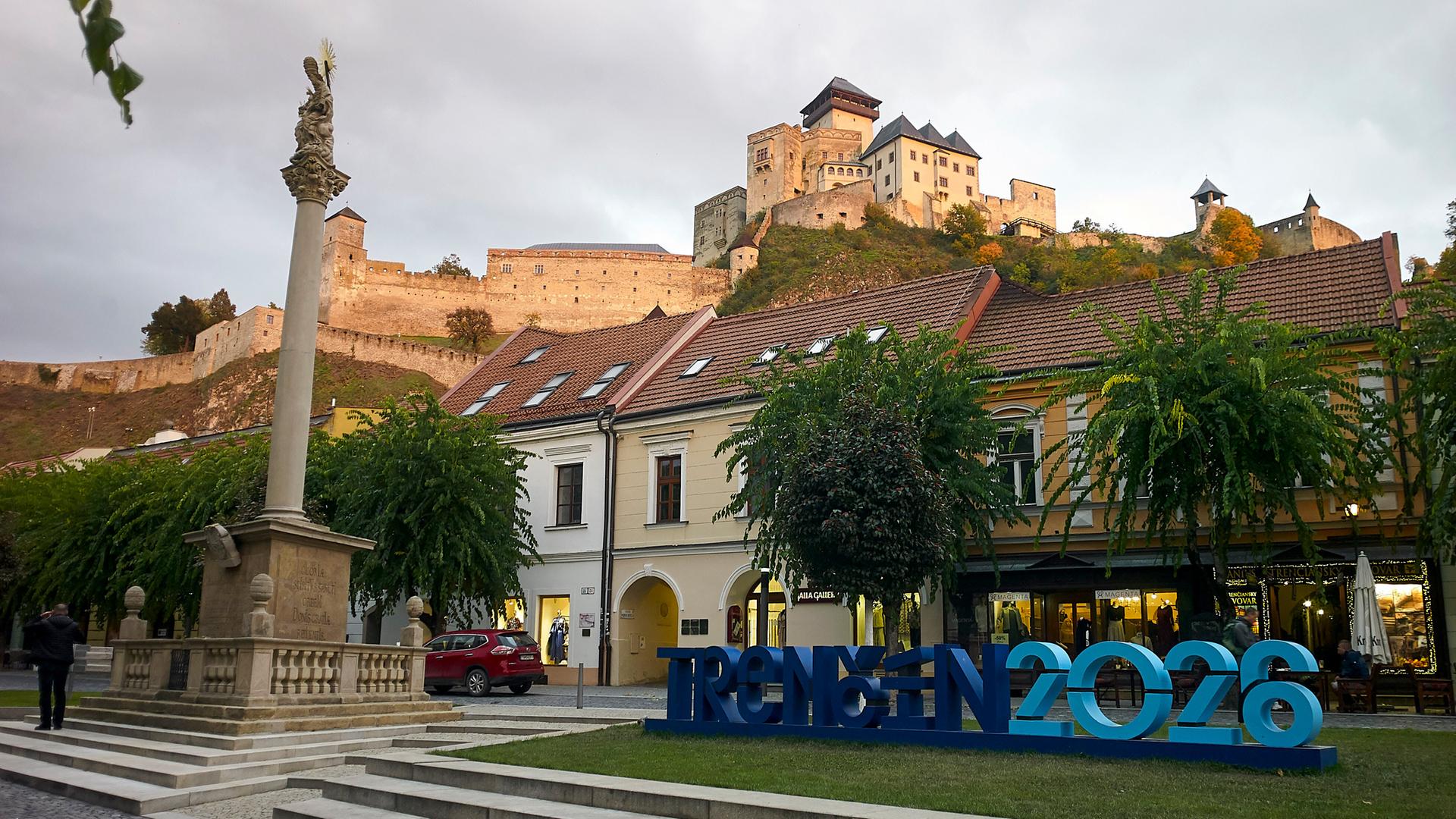 Blick auf die Mariensäule aus dem Jahr 1712 mit der mittelalterlichen Burganlage im Hintergrund im slowakischen Trenčín, das neben dem finnischen Oulu Kulturhauptstadt Europas 2026 ist.