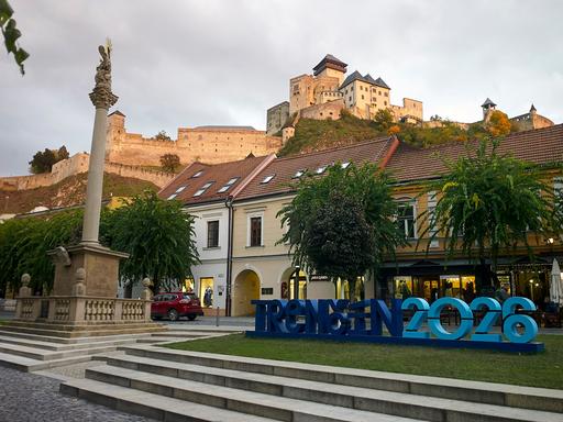 Blick auf die Mariensäule aus dem Jahr 1712 mit der mittelalterlichen Burganlage im Hintergrund im slowakischen Trenčín, das neben dem finnischen Oulu Kulturhauptstadt Europas 2026 ist.