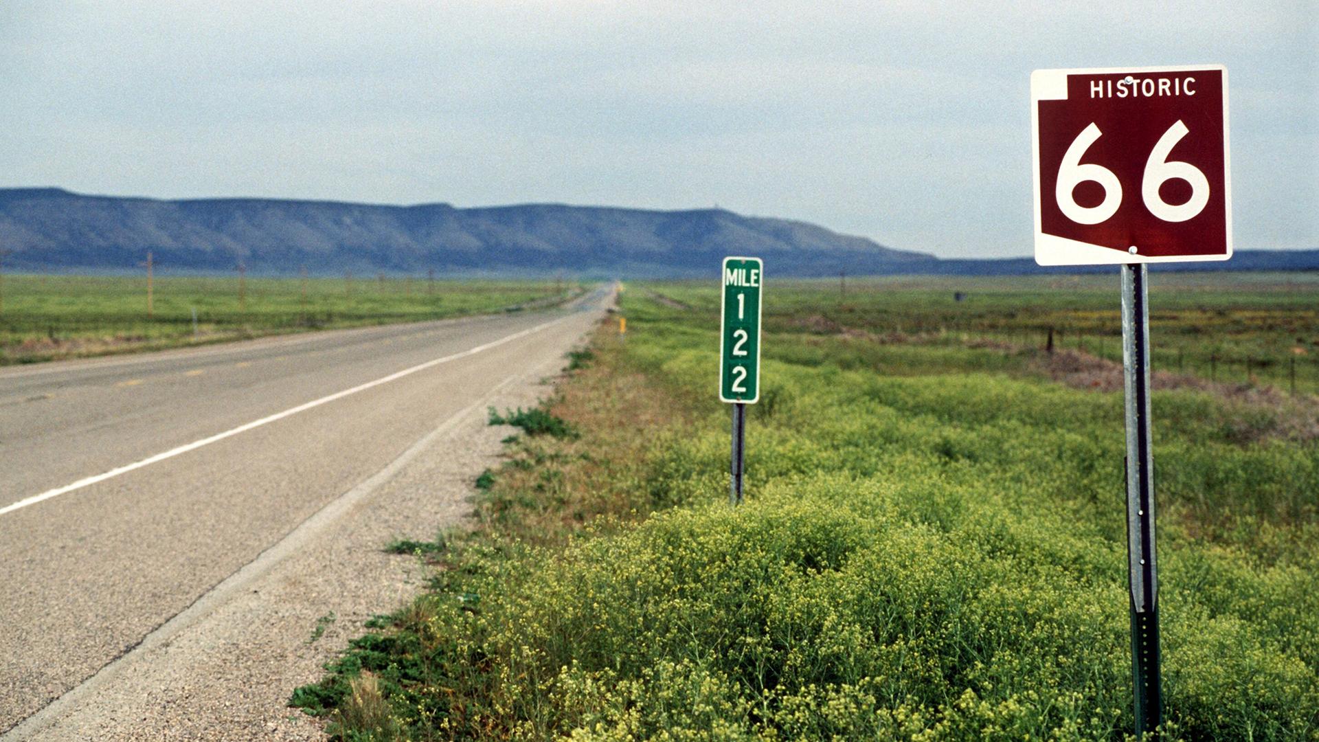 Straßenschild an der historischen "Route 66" bei Seligman. Im Hintergrund sind die Berge zu sehen.
