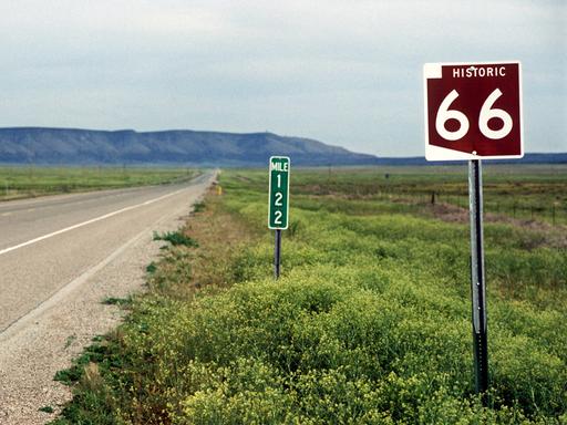 Straßenschild an der historischen "Route 66" bei Seligman. Im Hintergrund sind die Berge zu sehen.