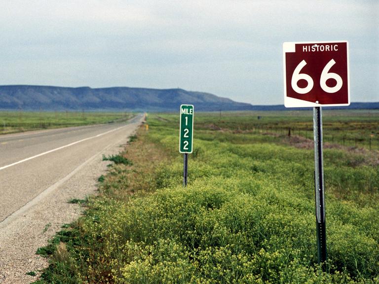 Straßenschild an der historischen "Route 66" bei Seligman. Im Hintergrund sind die Berge zu sehen.