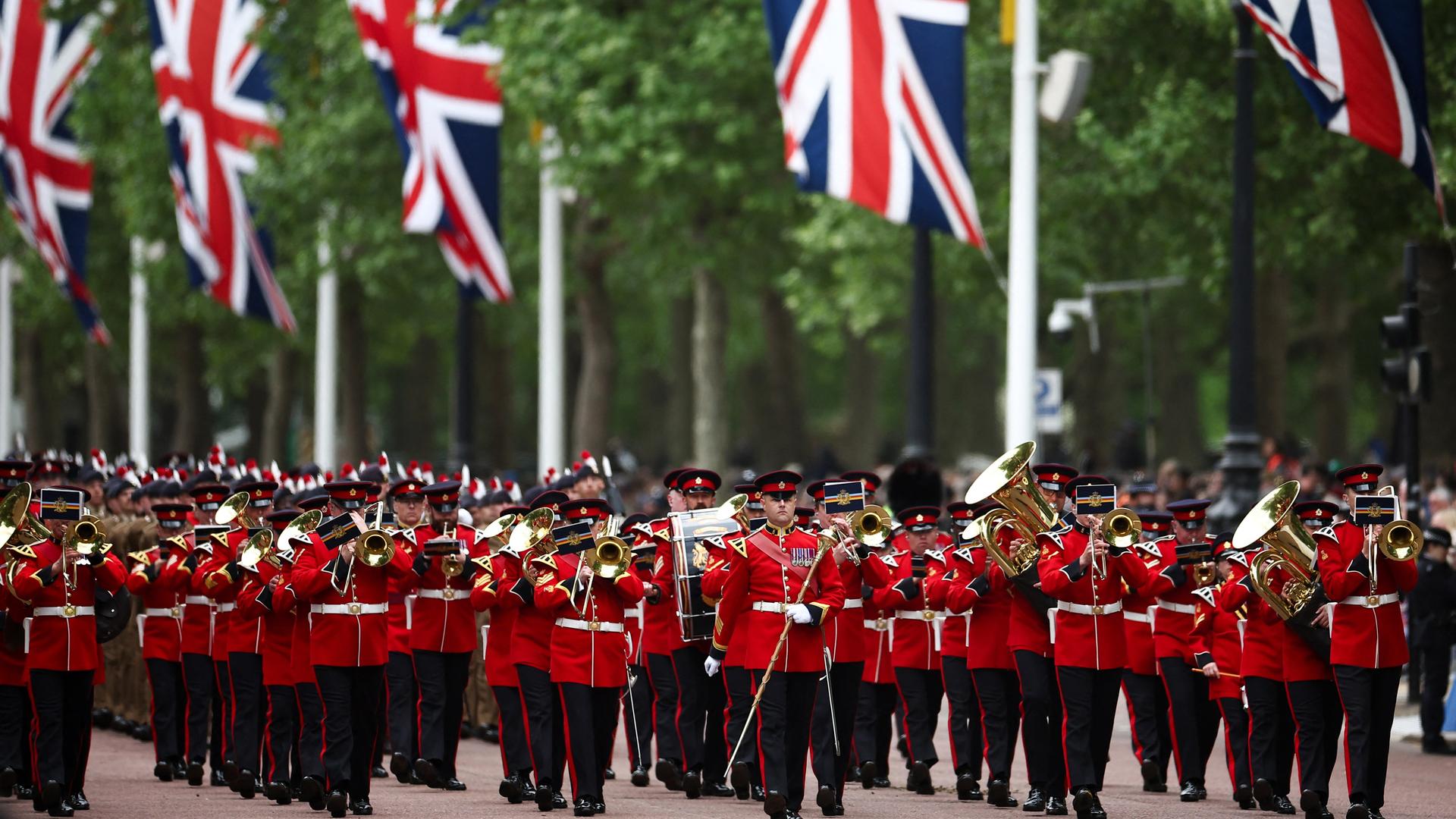 Eine Militärparade in London: Zu sehen ist ein marschierendes Musikkorps, im Hintergrund sind britische Flaggen zu erkennen. 