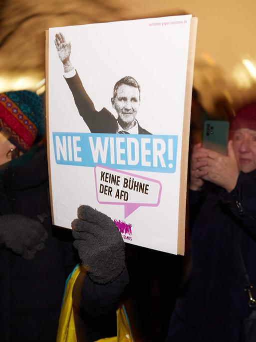 Eine Demonstrantin hält ein Plakat mit dem AfD-Funktionär Björn Höcke, der seine Hand zum Hitlergruß hebt. Darunter steht: "Nie wieder. Keine Bühne der AfD"