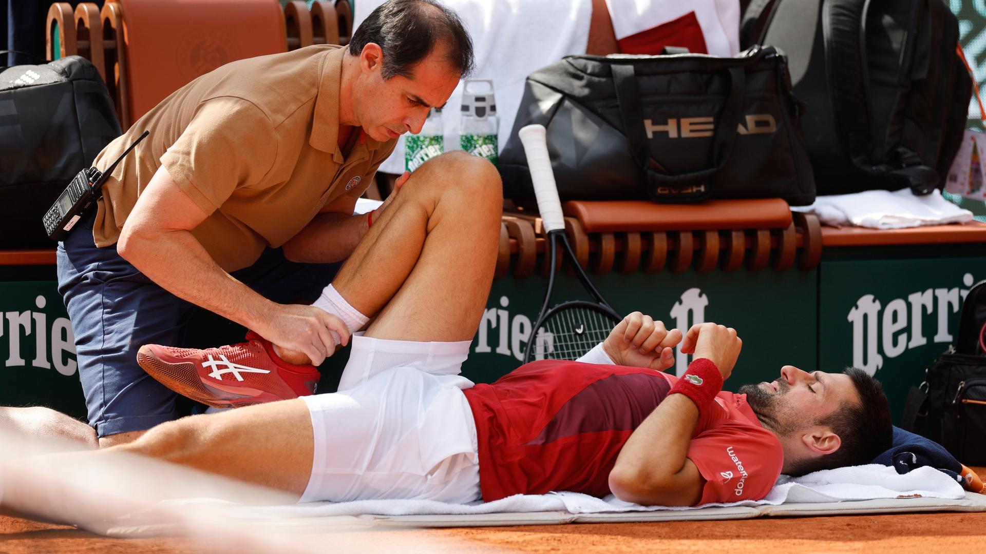 Der serbische Tennisspieler Novak Djokovic wird während seines Viertrundenmatches bei den French Open gegen den Argentinier Francisco Cerundolo in Paris medizinisch versorgt. 