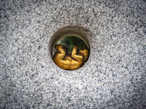 Der Grabstein eines Sternenkindergrabes auf einem Friedhof in Reinickendorf. In einem Kreis liegt ein Fötus aus Bronze. Der Grabstein eines Sternenkindergrabes auf einem Friedhof in Reinickendorf. In einem Kreis liegt ein Fötus aus Bronze.