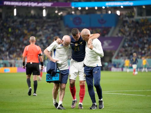 France's Lucas Hernandez is helped off the pitch during the World Cup group D soccer match between France and Australia, at the Al Janoub Stadium in Al Wakrah, Qatar, Tuesday, Nov. 22, 2022. (AP Photo/Christophe Ena)