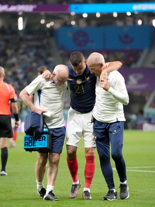 France's Lucas Hernandez is helped off the pitch during the World Cup group D soccer match between France and Australia, at the Al Janoub Stadium in Al Wakrah, Qatar, Tuesday, Nov. 22, 2022. (AP Photo/Christophe Ena)