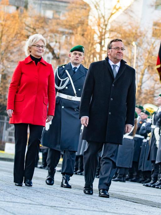 Beim Zapfenstreich zur Amtsübergabe schreiten Christine Lambrecht und Boris Pistorius die Garde von Bundeswehrsoldaten ab.
