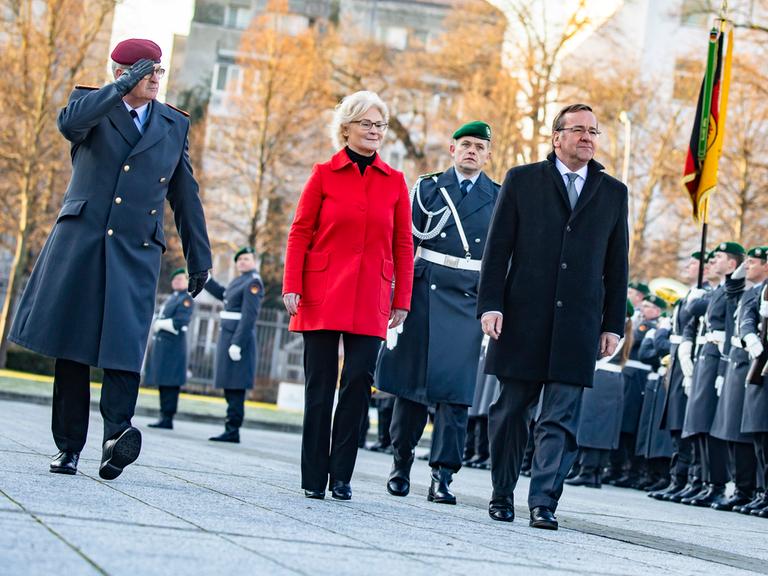 Beim Zapfenstreich zur Amtsübergabe schreiten Christine Lambrecht und Boris Pistorius die Garde von Bundeswehrsoldaten ab.