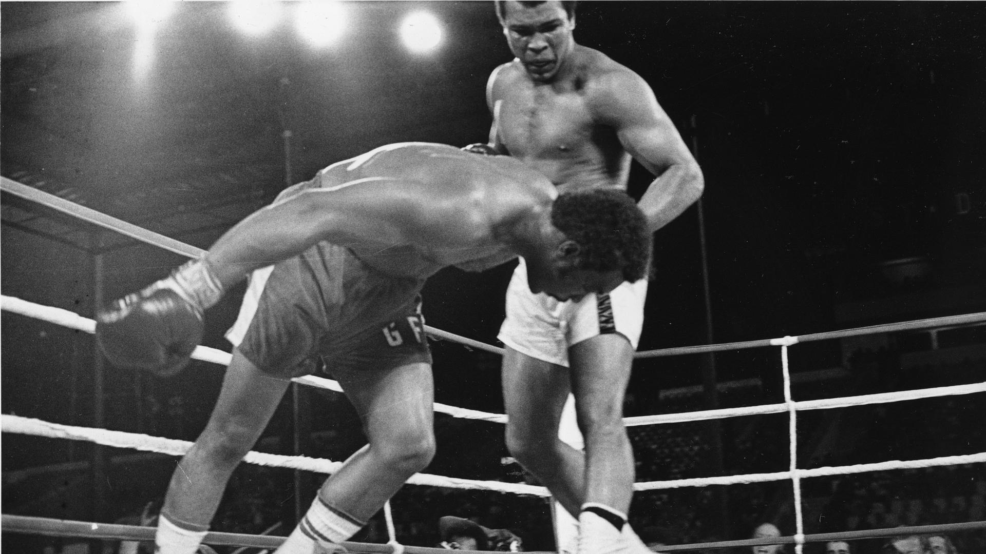 Challenger Muhammad Ali watches as defending world champion George Foreman goes down to the canvas in the eighth round of their WBA/WBC championship match in Kinshasa, Zaire, on October 30, 1974. Foreman is counted out by the referee and Ali regains the world heavyweight crown by KO in the bout dubbed 'Rumble in the Jungle.' (AP Photo)