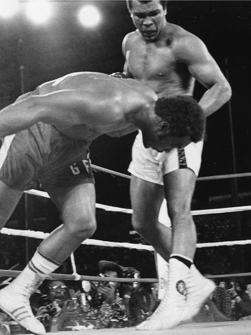 Challenger Muhammad Ali watches as defending world champion George Foreman goes down to the canvas in the eighth round of their WBA/WBC championship match in Kinshasa, Zaire, on October 30, 1974. Foreman is counted out by the referee and Ali regains the world heavyweight crown by KO in the bout dubbed 'Rumble in the Jungle.' (AP Photo)