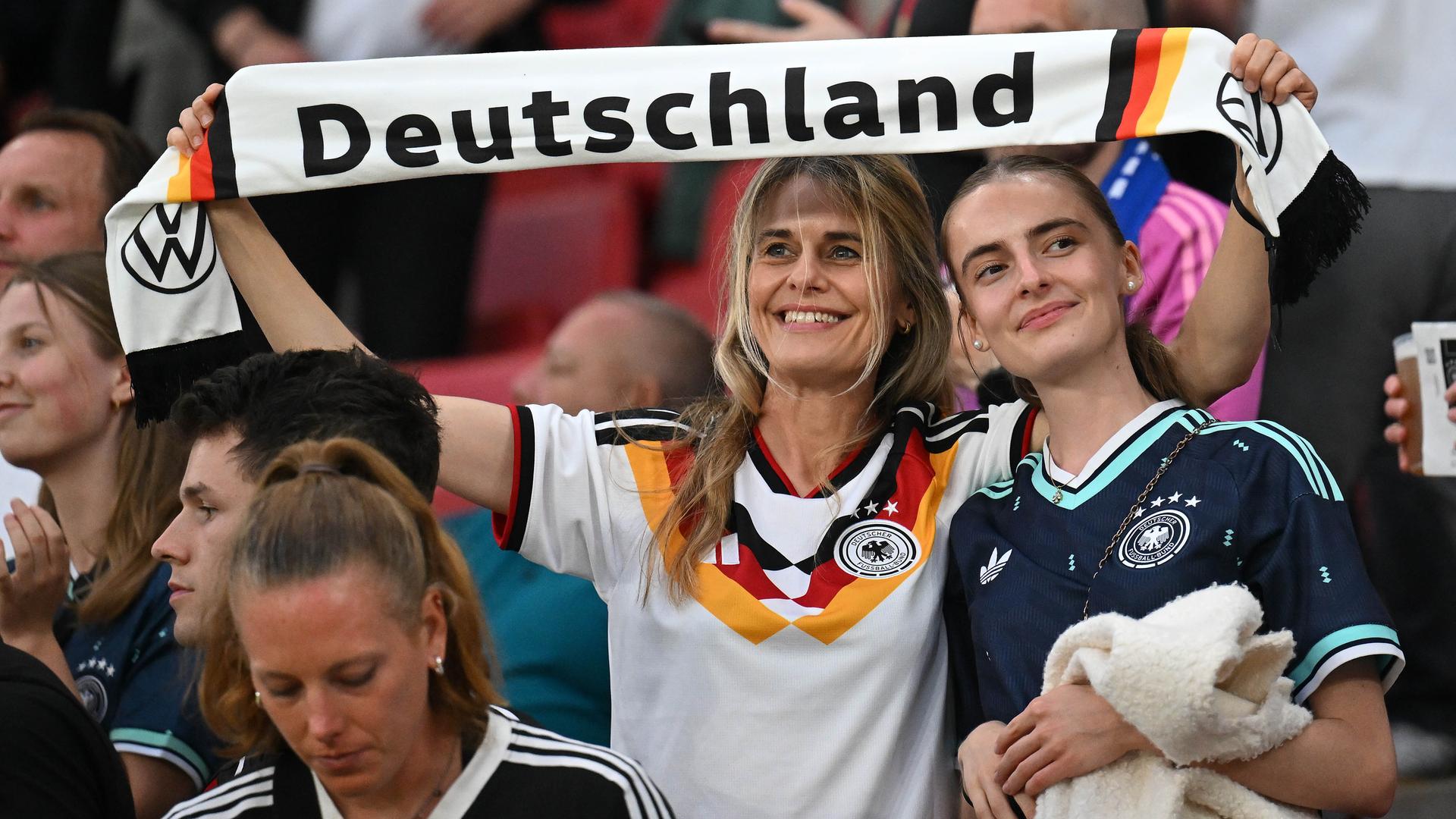 Zwei weibliche deutsche Fans mit Schal bei einem Fussballspiel