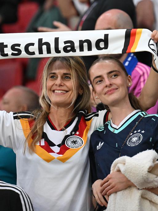 Zwei weibliche deutsche Fans mit Schal bei einem Fussballspiel
