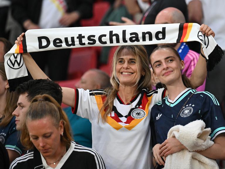 Zwei weibliche deutsche Fans mit Schal bei einem Fussballspiel