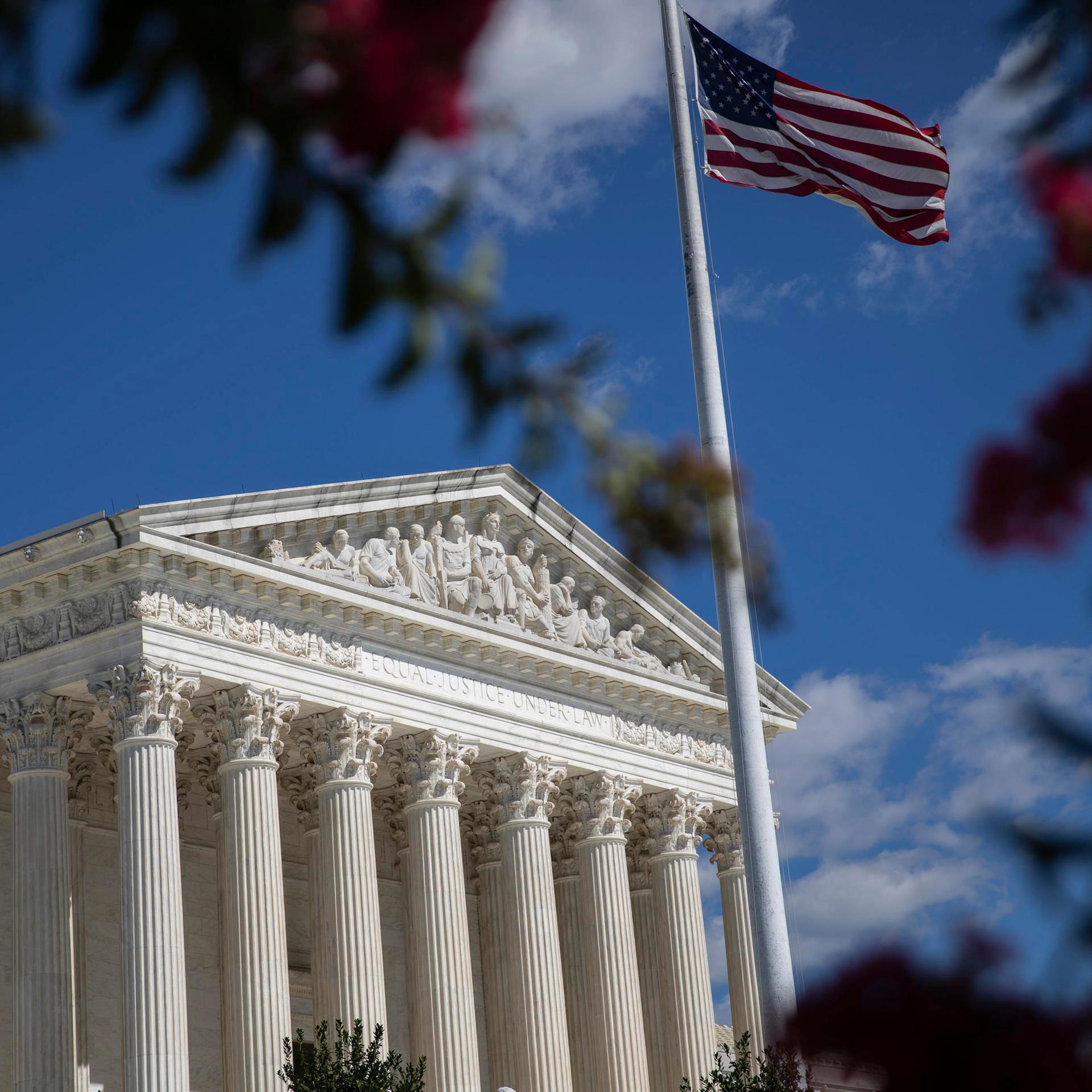 Blick auf den US Supreme Court in Washington, im Vordergrund die amerikanische Flagge