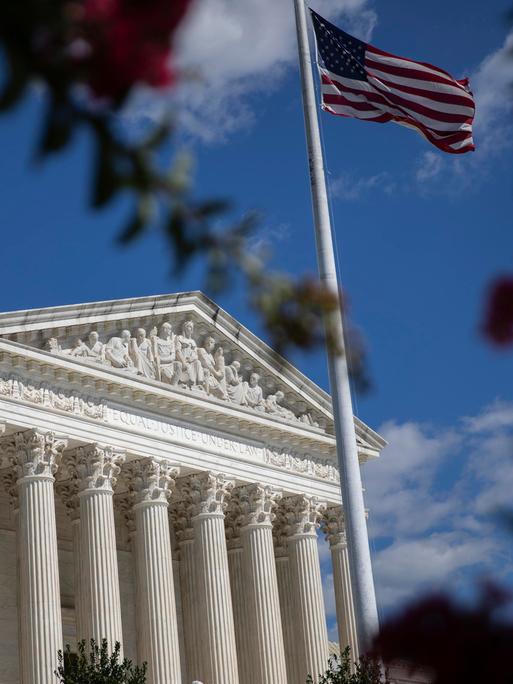 Blick auf den US Supreme Court in Washington, im Vordergrund die amerikanische Flagge
