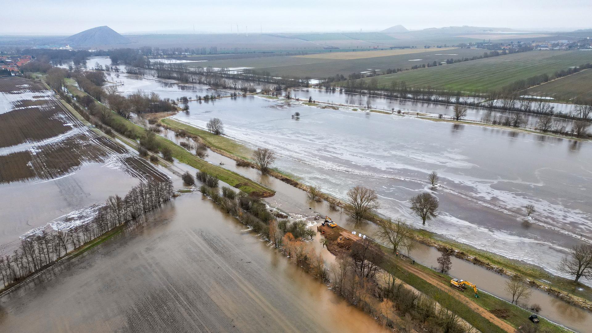 Eine überflutete Landschaft mit überspülten Feldern und Straßen.