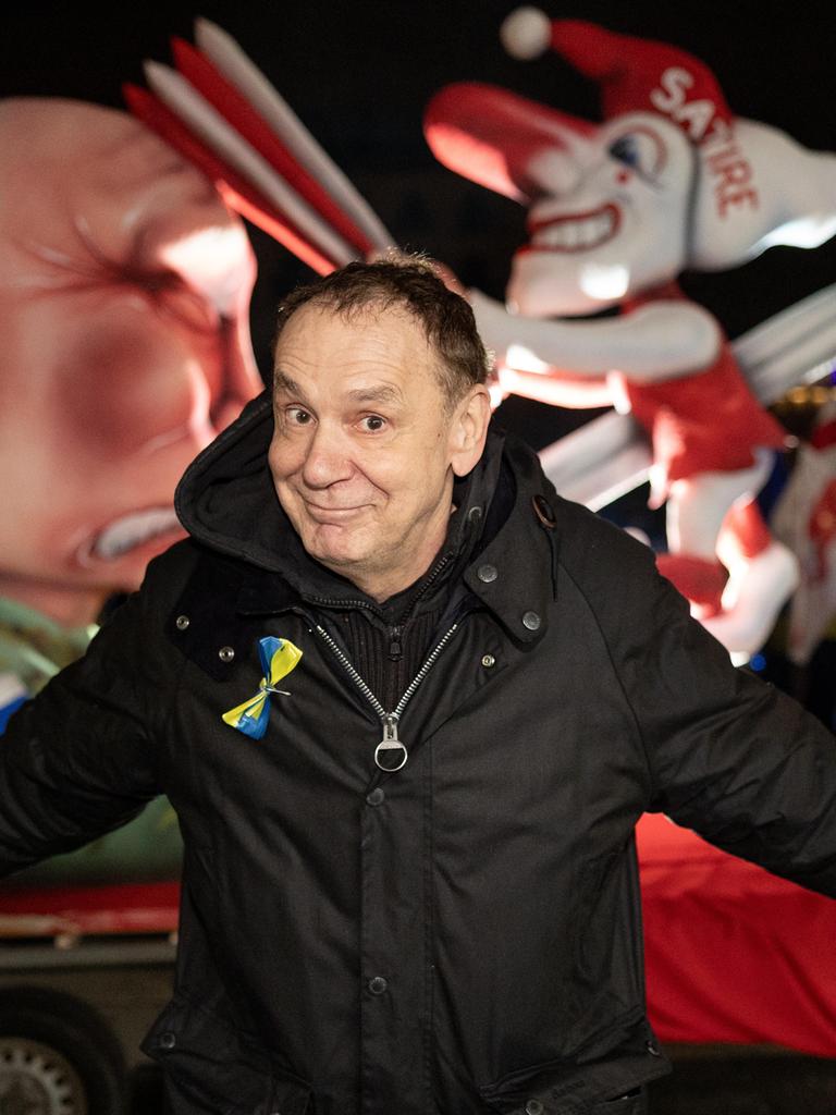 Der Künstler Jacques Tilly steht vor seinem Mottowagen "Putin spießt den Düsseldorfer Hoppeditz auf" bei einer Kundgebung auf dem Roncalliplatz in Köln anlässlich des Jahrestages des russischen Großangriffs auf die Ukraine.