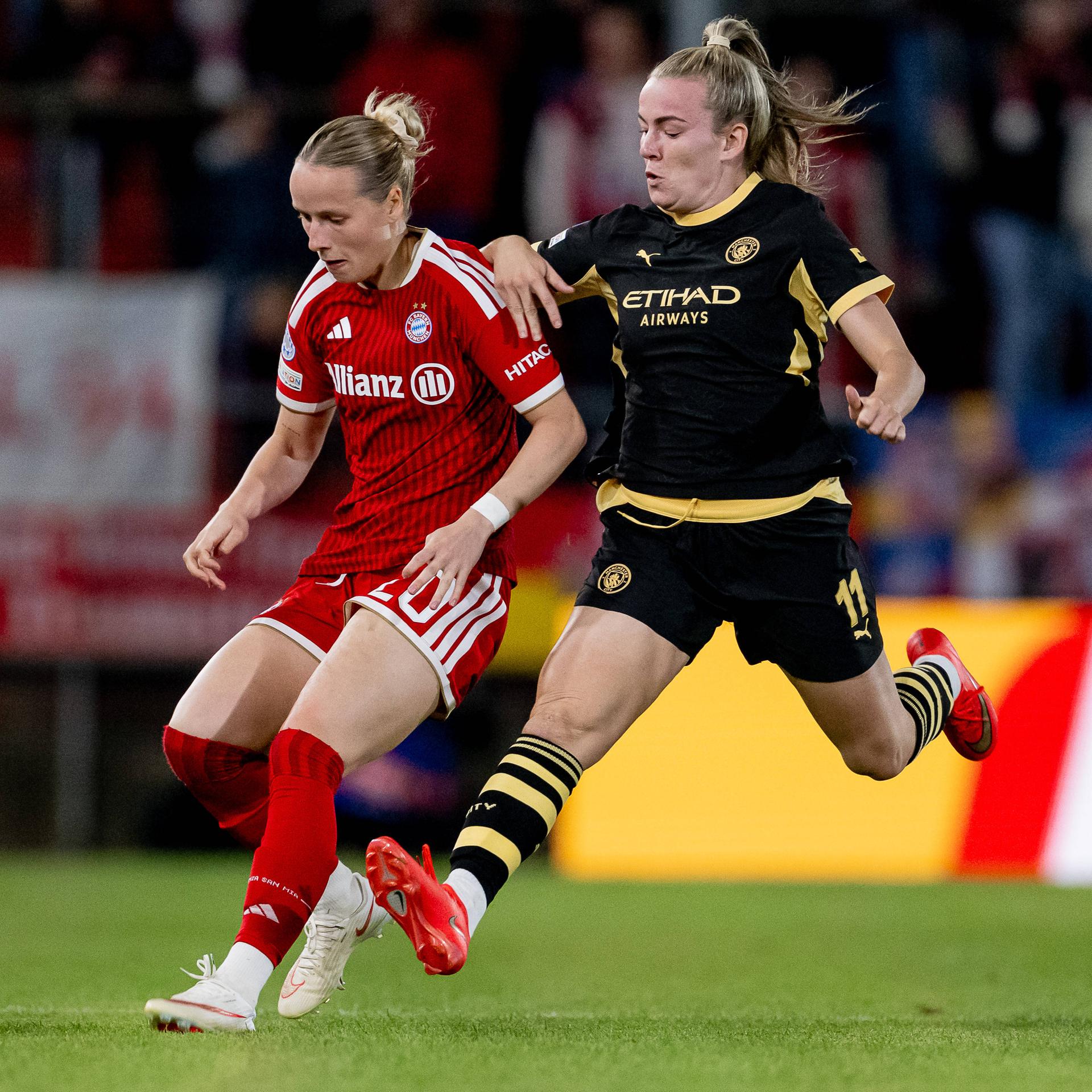 Zu sehen sind die Fußballerinnen Franziska Kett vom FC Bayern München und Lauren Hemp von Manchester City auf dem Spielfeld.
