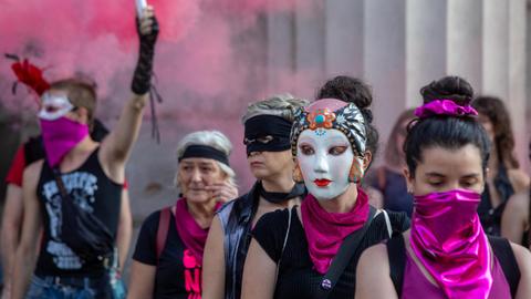 Aktivistinnen haben sich in Mailand versammelt: Sie sind mit lila Halstüchern maskiert oder tragen Masken. Es gibt auch lila Rauch. Es ist eine "Nicht-eine-Weniger"-Aktion gegen Femizide.